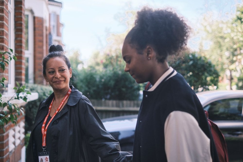 Young girl approaches new foster home with support worker, acted by Chan, one of Action for Children's young ambassadors
