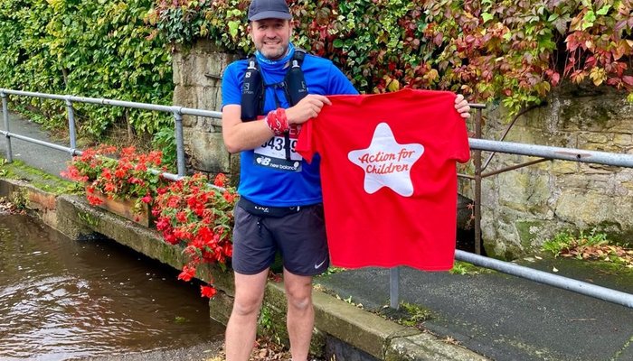 Action for Children runner holding t-shirt