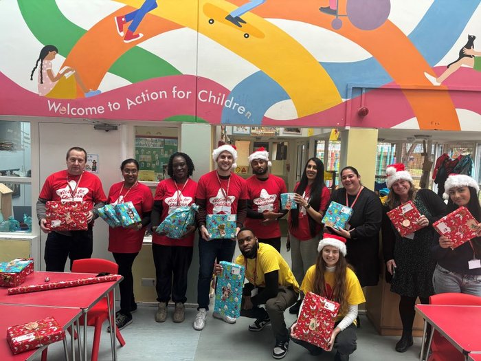 A group of Action for Children works holding Christmas presents.
