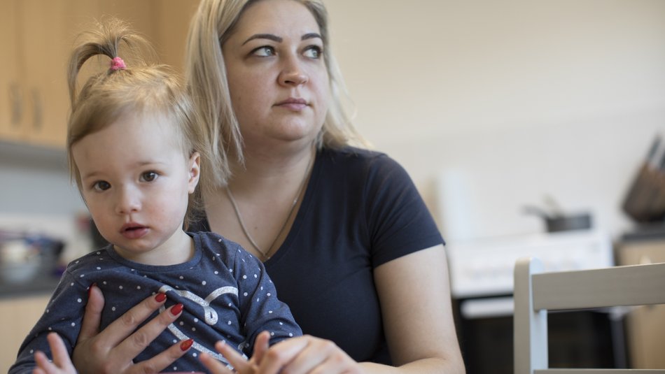 Mum Natalia and daughter sat at kitchen table
