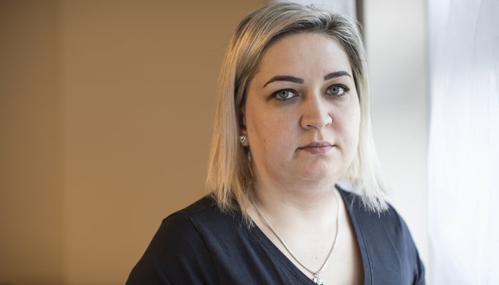 Blonde woman looking into the camera with neutral expression
