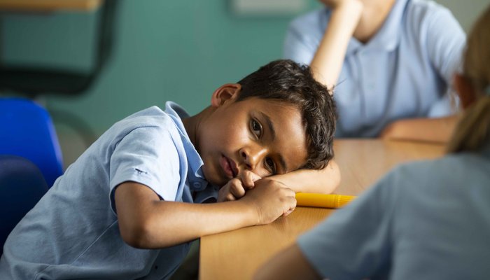 Tired boy at school desk