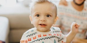 Baby in a Christmas baby grow