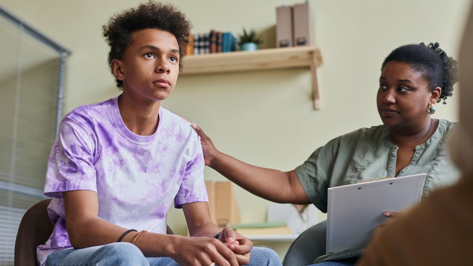 Boy sat down in a support appointment with a woman