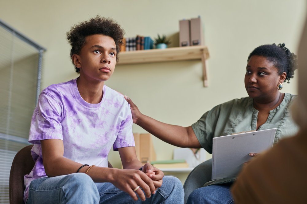 Boy sat down in a support appointment with a woman