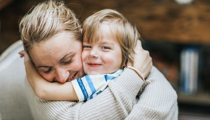 Child hugging mum and smiling