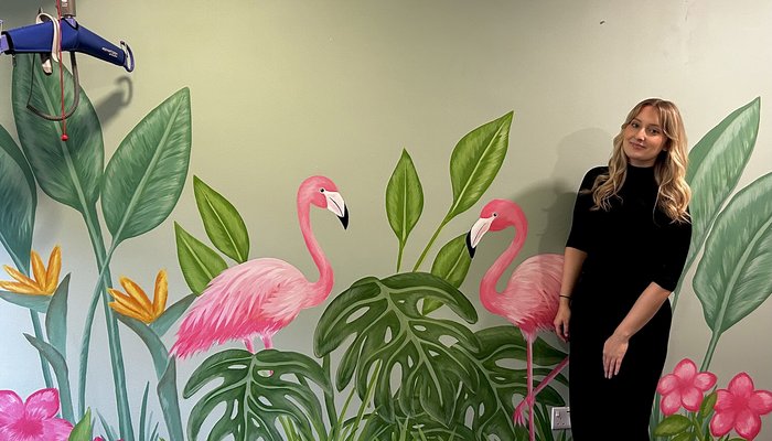 Emily Blythe standing in front of wall she has decorated