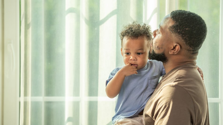 Father holding son looking into distance