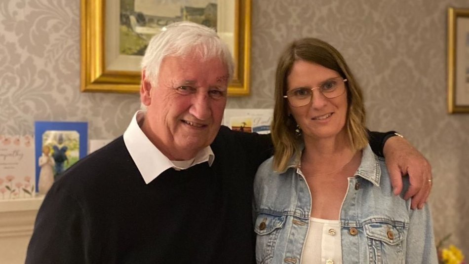 Foster parent Karen and her father Sam stood in living room together and smiling 2