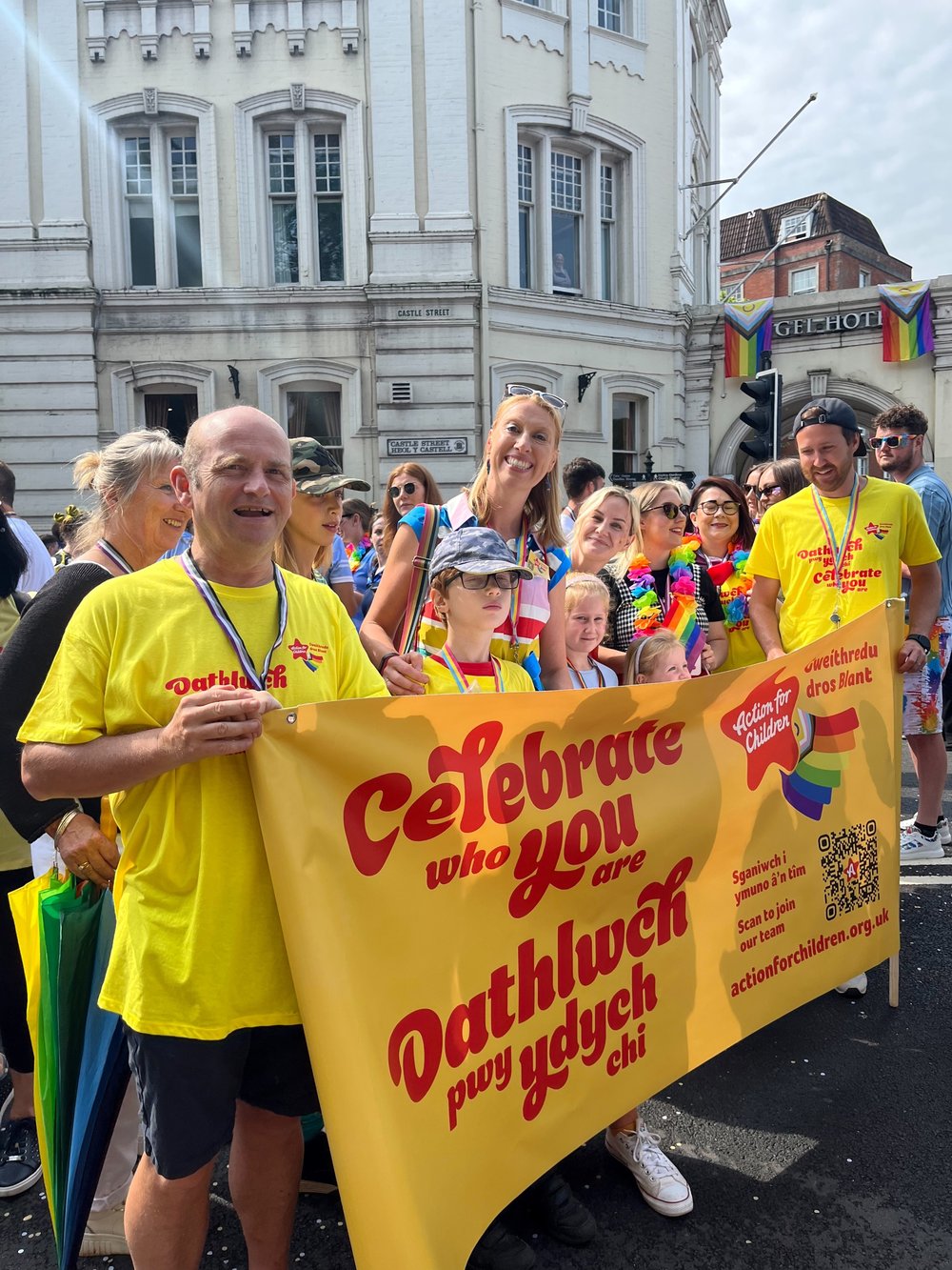 Group at pride with 'celebrate who you are' banner