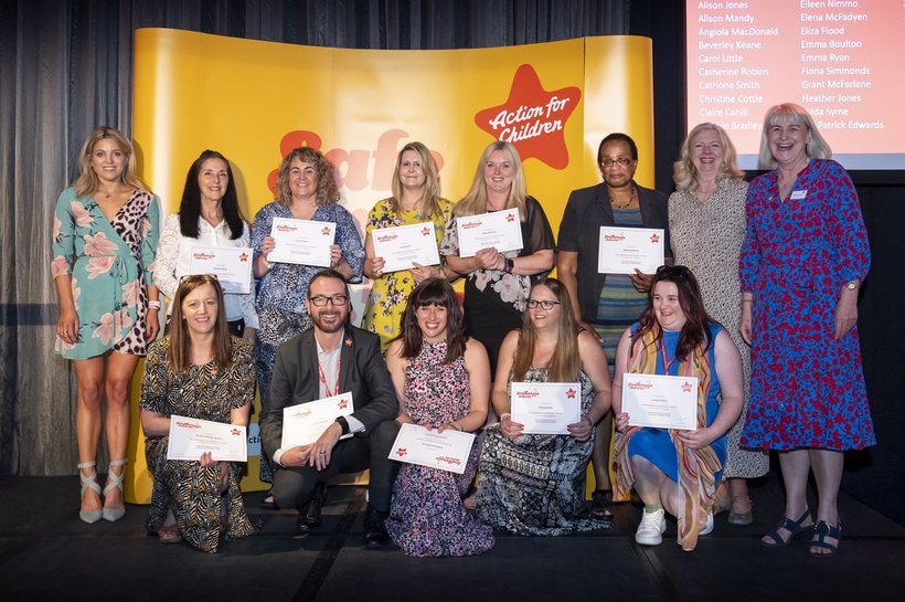 Group of winners at Action for Children's Stephenson Award smiling at the camera holding their certificates