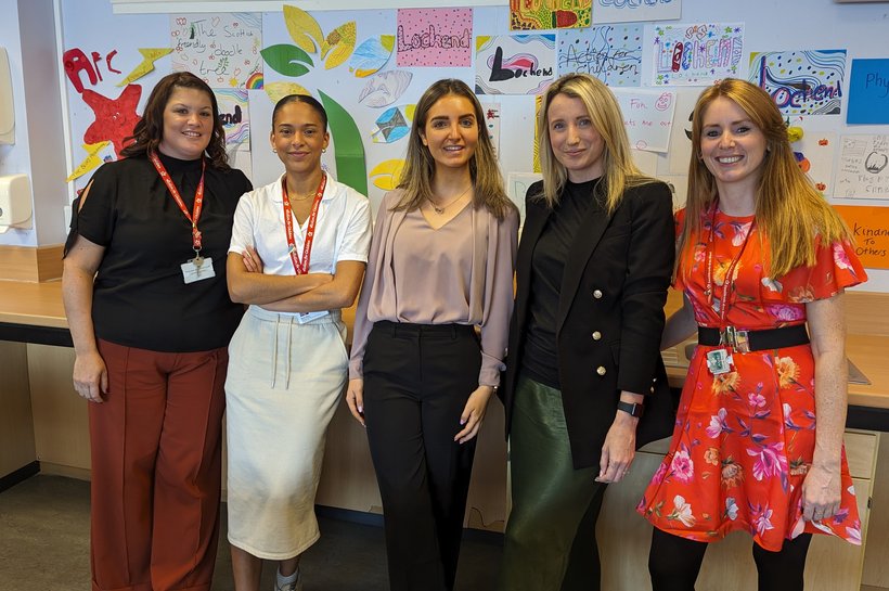 Group of women smiling at camera in classroom