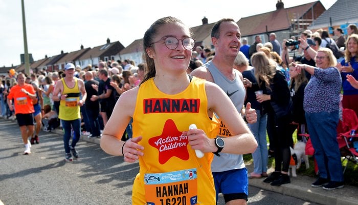 Hannah in a yellow Action for Children running vest at the Great North Run