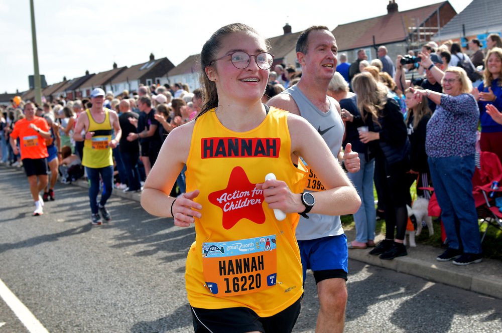 Hannah in a yellow Action for Children running vest at the Great North Run