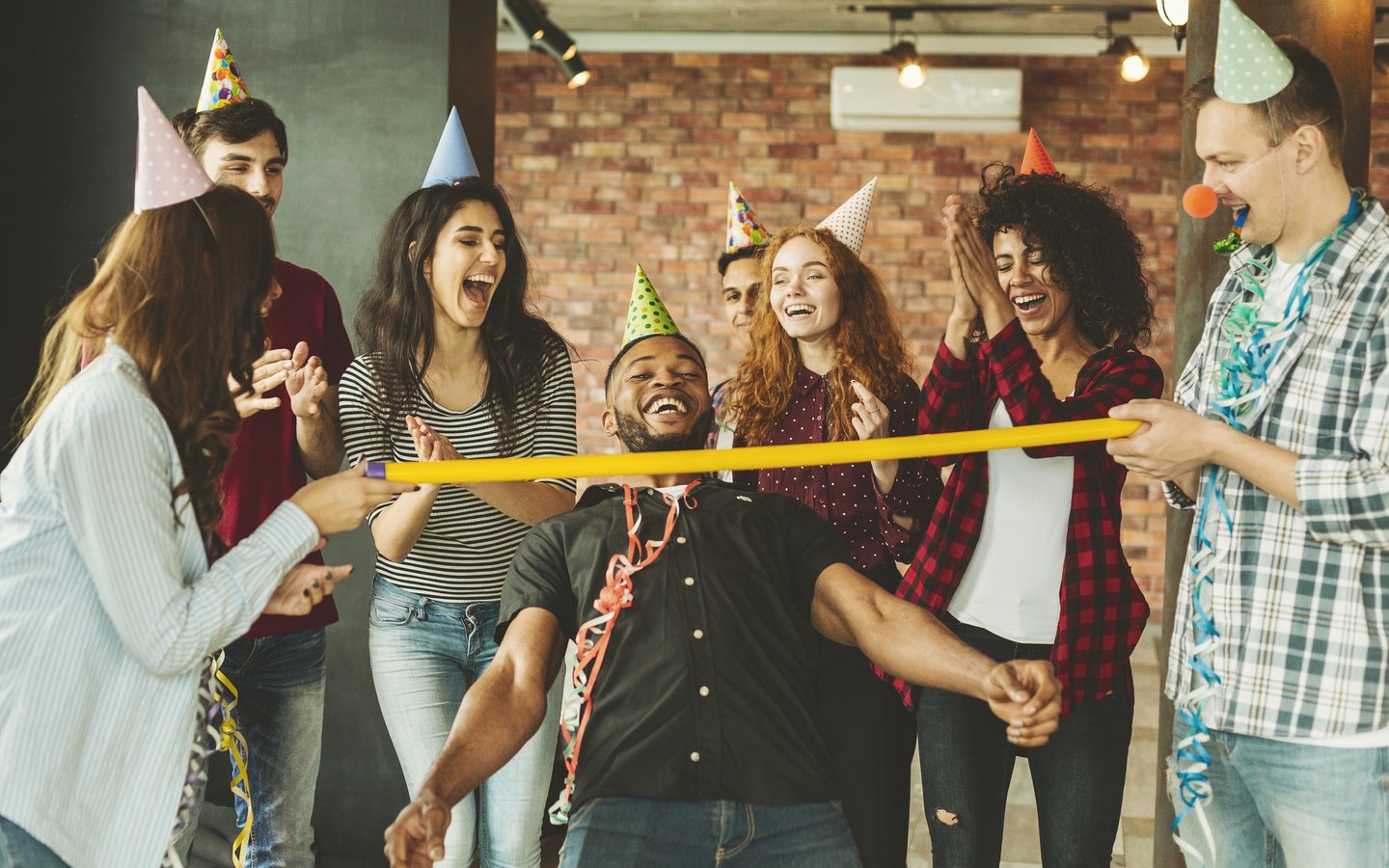 Happy friends playing Limbo at party