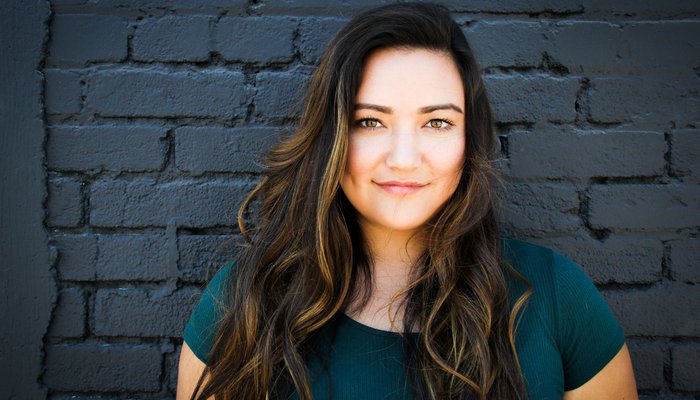 Happy woman in front of black brick wall