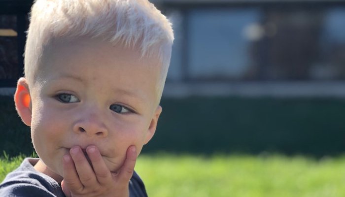 Little boy with hand on his mouth concentrating