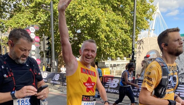 Action for Children runner waving at the the London Marathon
