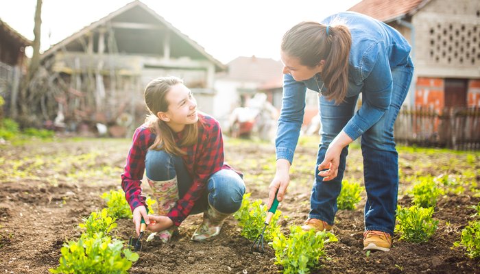 Mother and daughter working in garden