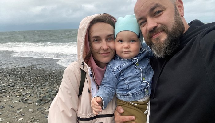 Mum and dad take a sefie with their baby at the beach