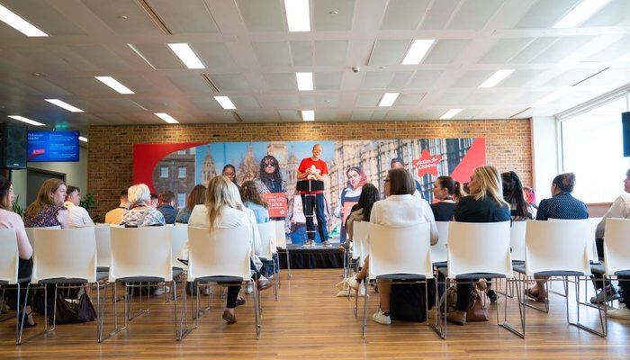 Man standing on a stage talking to an audience