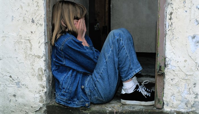 Young girl covering her face in her hands