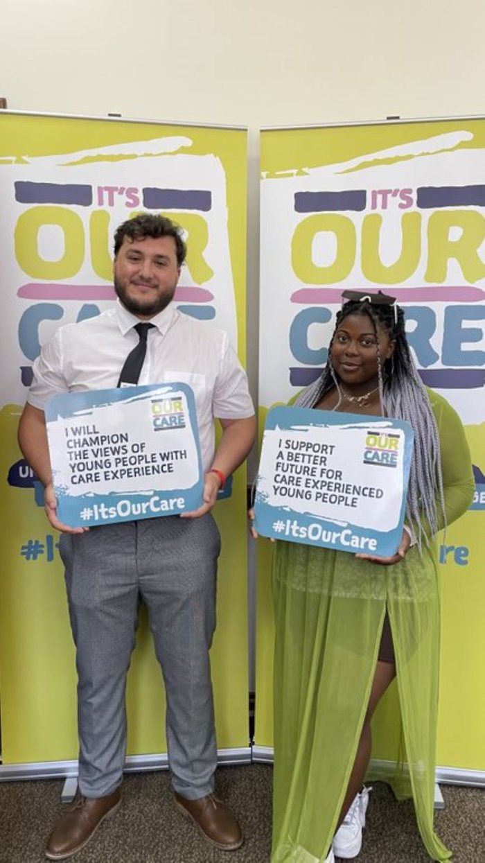 Young Ambassador Rachel standing with a man holding a card from an its our care event