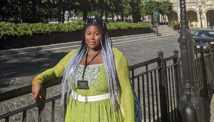 Young Ambassador Rachel standing in front of Big Ben wearing a green dress. (Landscape photo)