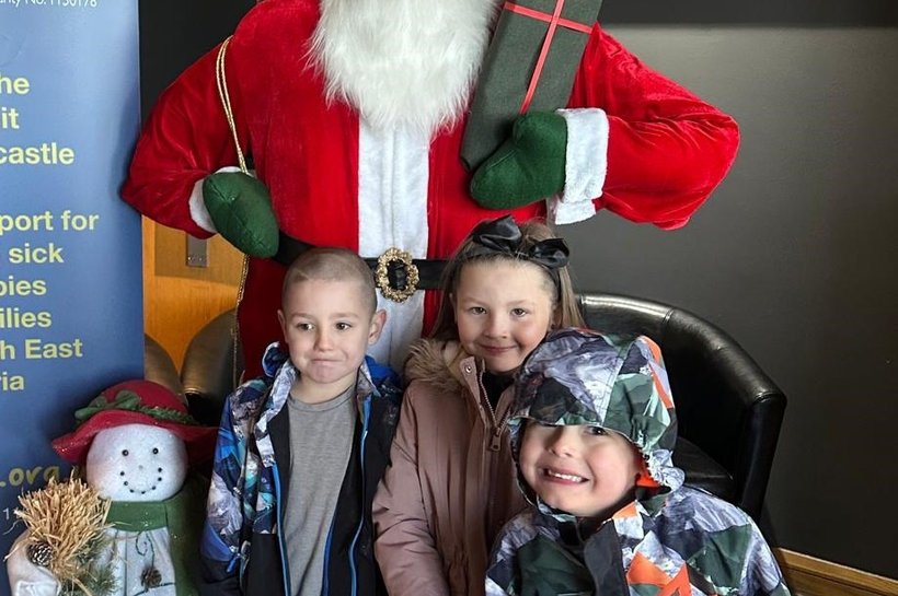 Happy children standing in front of Santa Clause