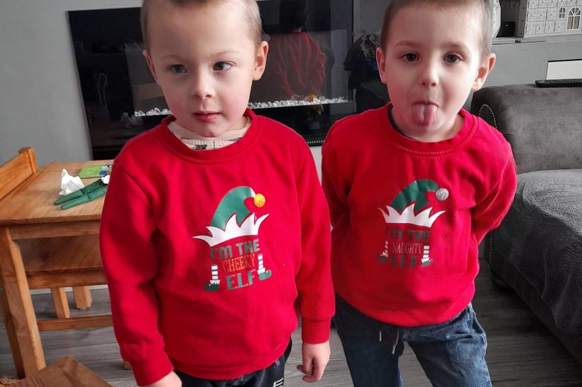 Twin boys in matching red Christmas jumpers