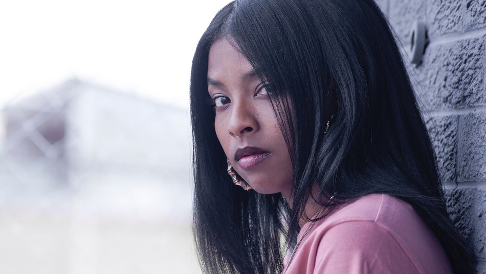 Serious teen leaning against wall