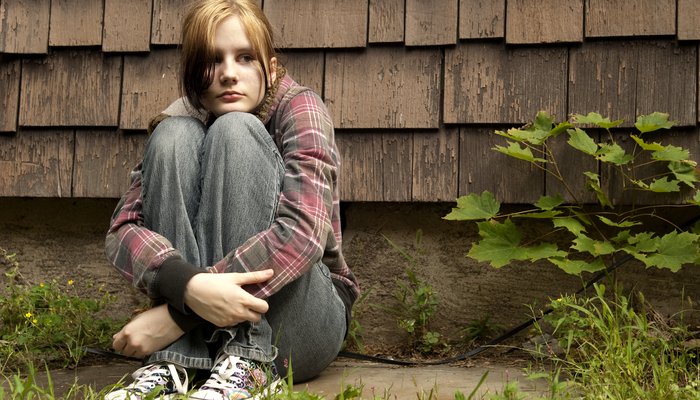 Teenage girl outside hands round knees.jpg