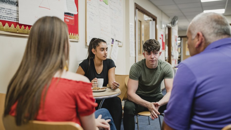 Small group o teenagers are talking to a mental health professional in a support group at the community centre