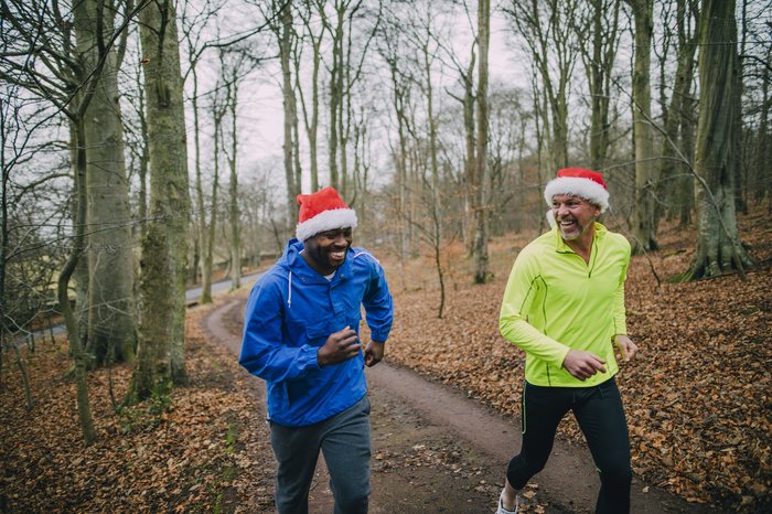 Sporty Santa Campaign - two men running in the forest with secret santa hats