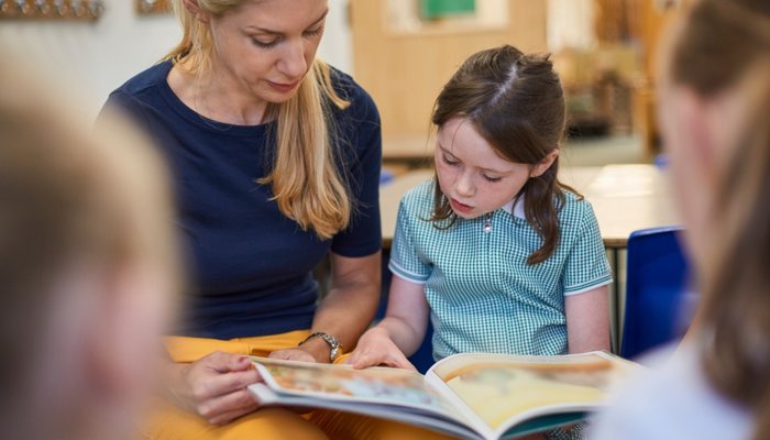 Teacher reading to young girl