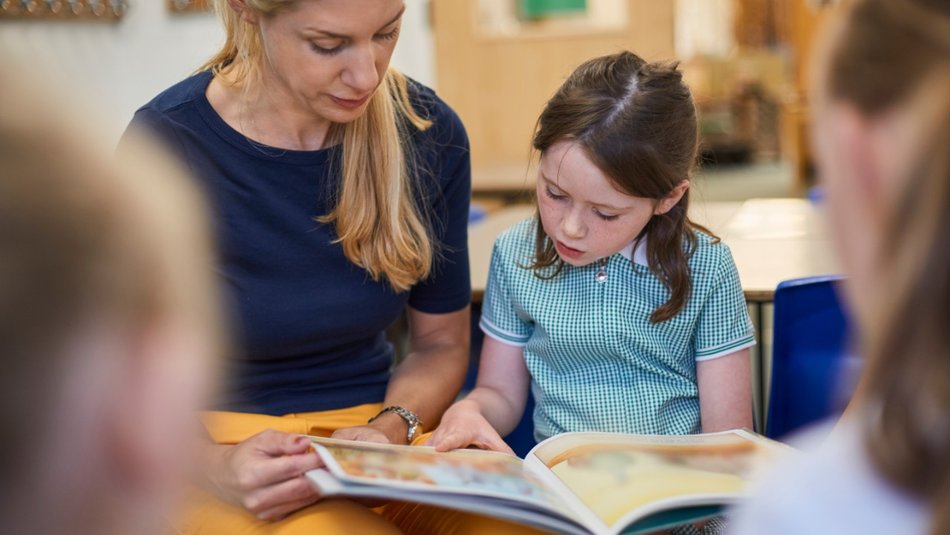 Teacher reading to young girl