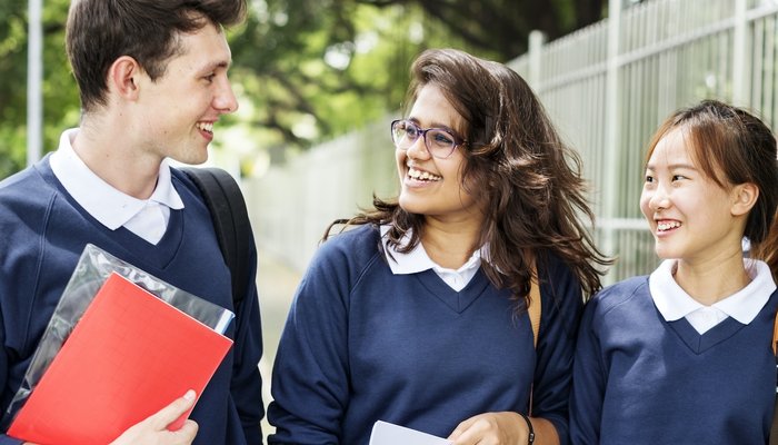 Teen school mates walking in the street with big smiles on their faces.jpg