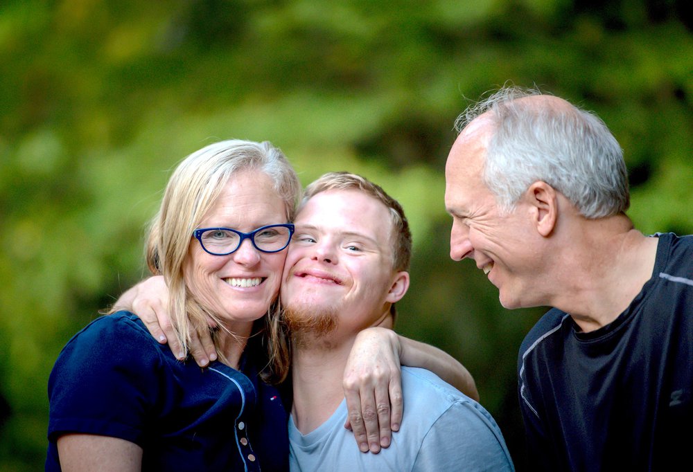 Teenage boy hugging parents.jpg