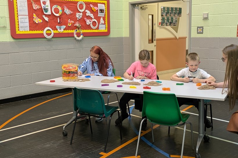 Three kids sat on a table playing