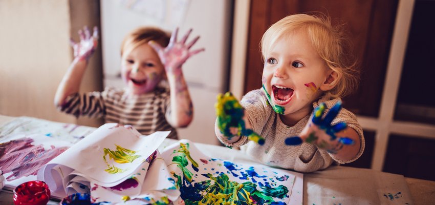 Two young girls painting with hands