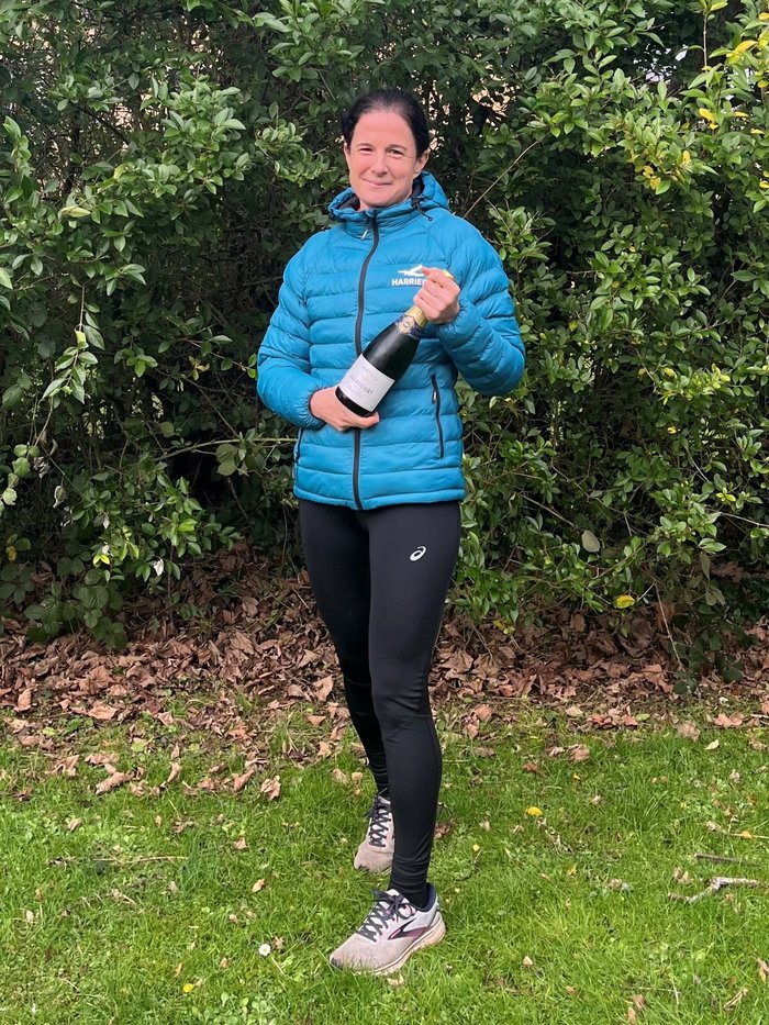 Vicky holding a bottle of wine after completing her sports challenge