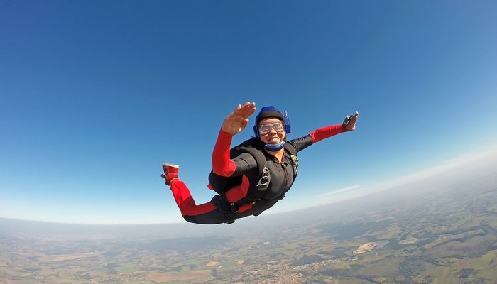 Woman in a red jumpsuit skydiving