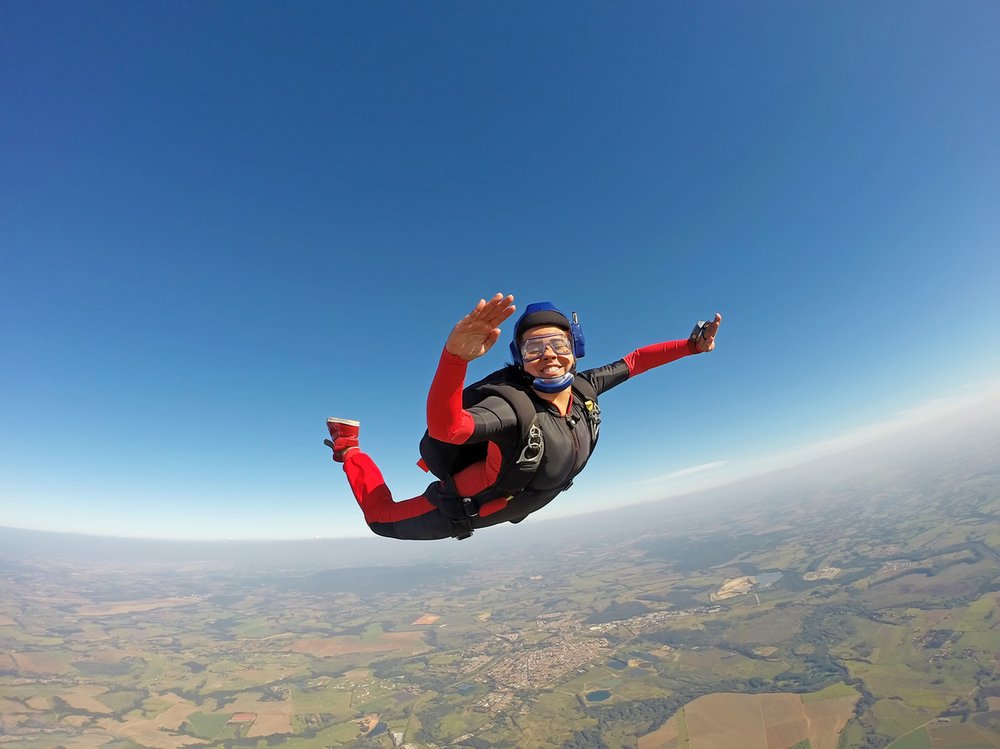 Woman in a red jumpsuit skydiving