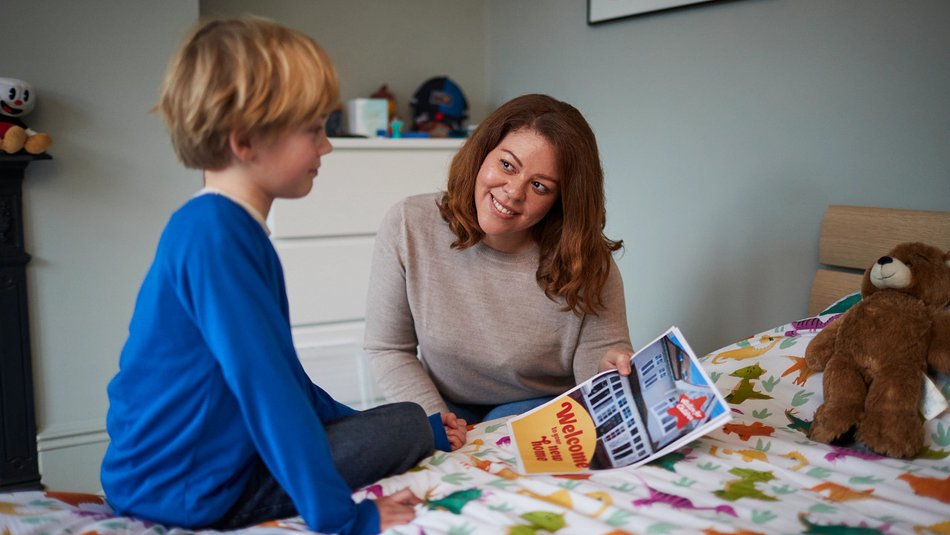 Woman showing child poster saying welcome to your new home