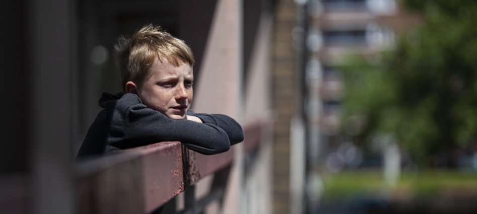 Young boy leaning on rail
