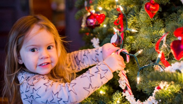 Young girl decorating Christmas tree