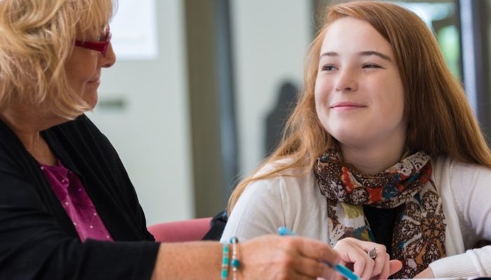 Young teenage girl and older lady sat having a conversation