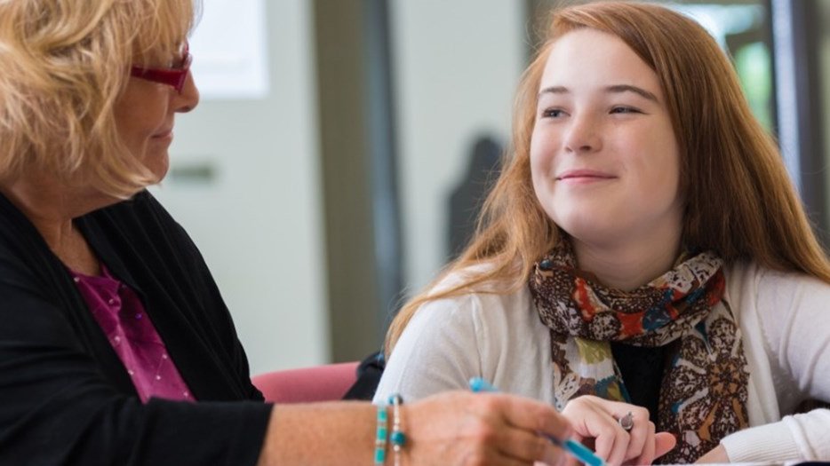Young teenage girl and older lady sat having a conversation