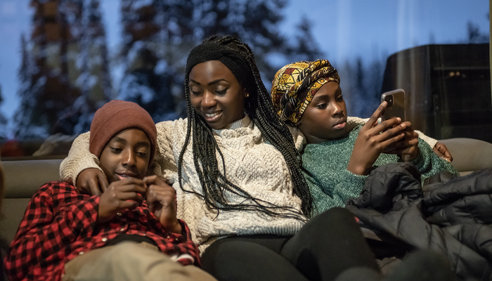 Mother and teenage children relaxing on the sofa