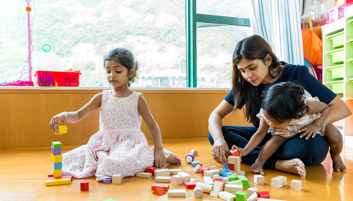 Mother and children together with play blocks.